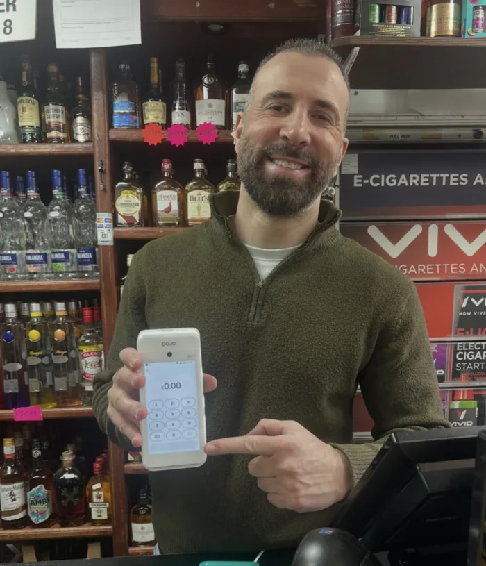 Akin of Hatfield Food & Wines holding a Dojo card machine