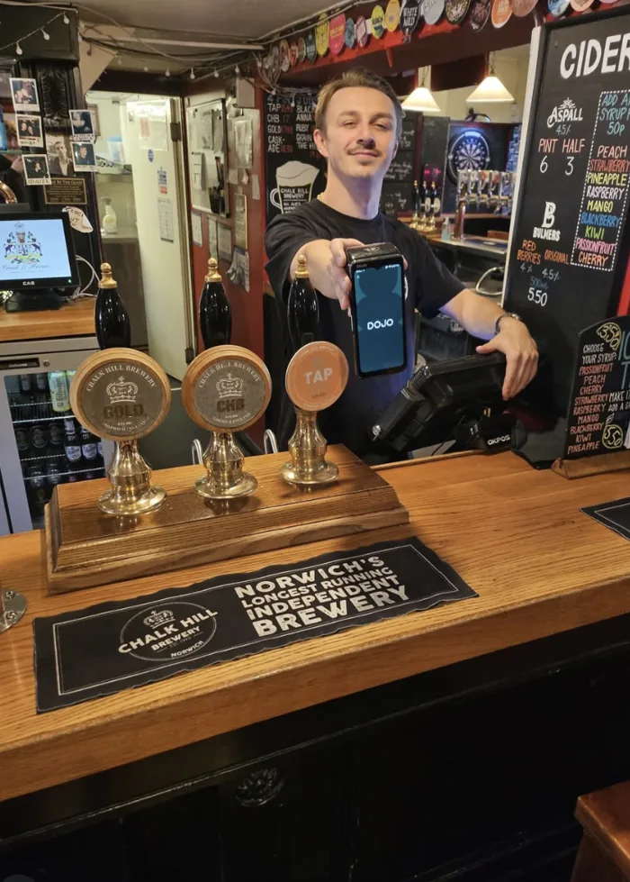 Cameron of Coaches & Horses holding a Dojo card machine
